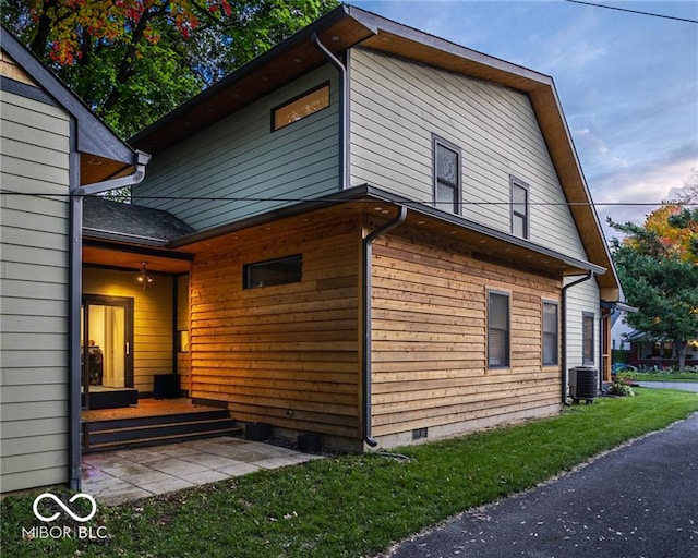 view of home's exterior with a yard and central air condition unit