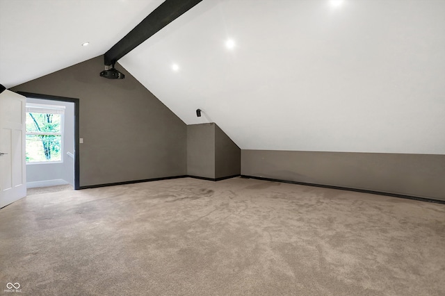 bonus room featuring light carpet, lofted ceiling with beams, and baseboards