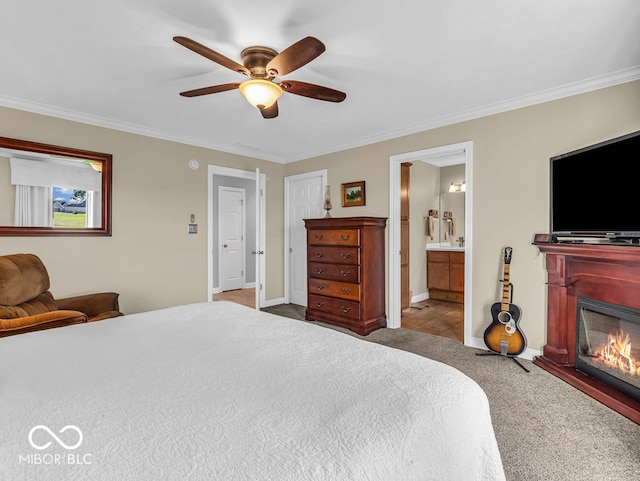 carpeted bedroom featuring ornamental molding, ceiling fan, and ensuite bathroom