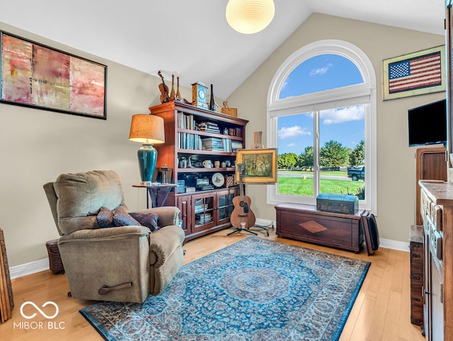 living area with light wood-type flooring and vaulted ceiling