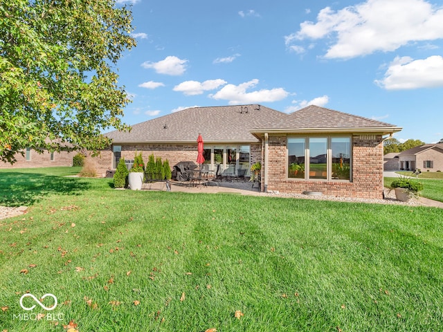 rear view of property with a lawn and a patio area