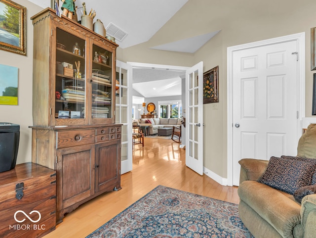 interior space with french doors, lofted ceiling, and light wood-type flooring