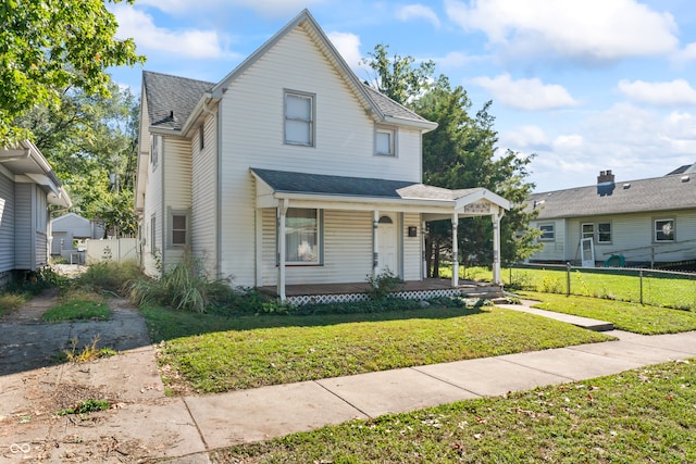 view of property featuring covered porch and a front yard