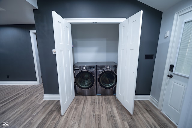 laundry area with hardwood / wood-style flooring and washing machine and dryer