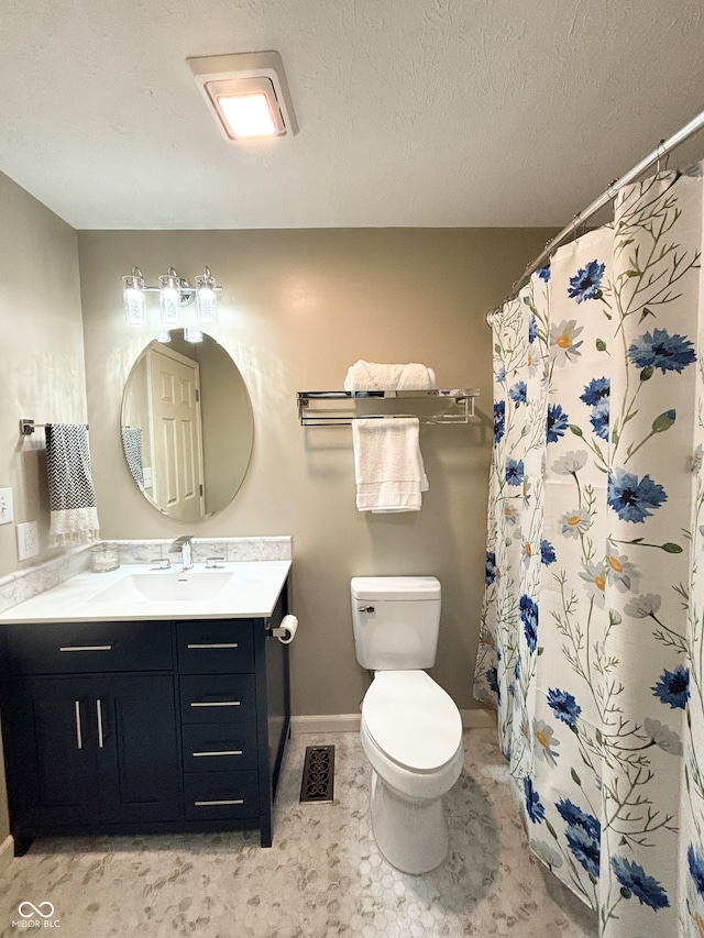 bathroom featuring a shower with shower curtain, vanity, toilet, and a textured ceiling