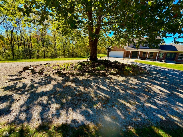 view of yard with covered porch and a garage