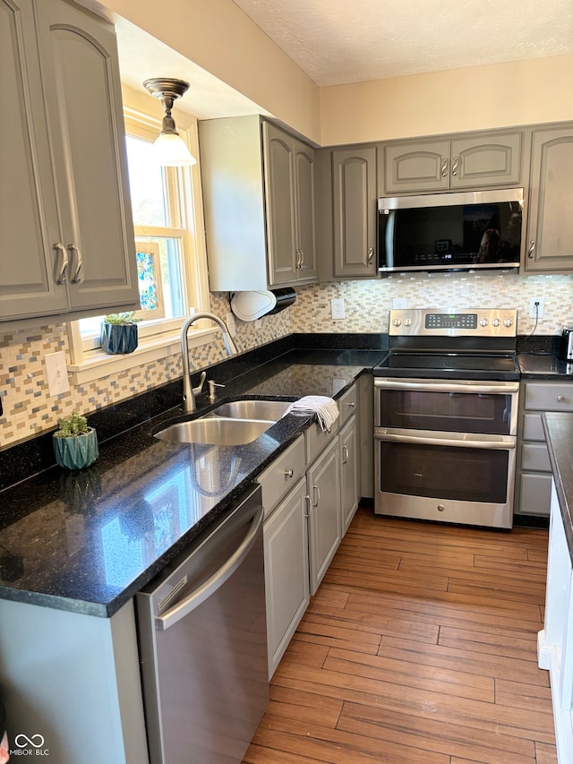 kitchen with gray cabinets, sink, stainless steel appliances, and light hardwood / wood-style floors