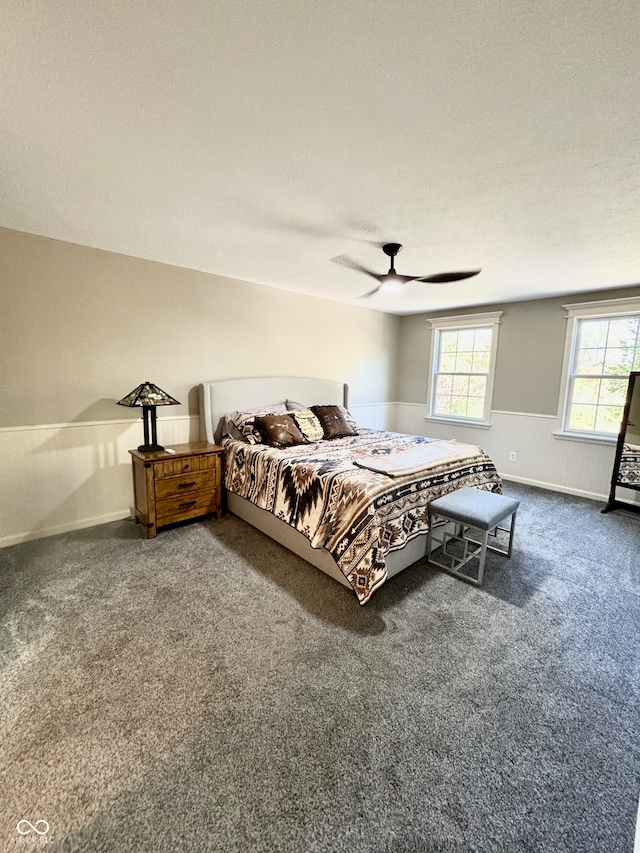 bedroom with ceiling fan, carpet floors, and a textured ceiling