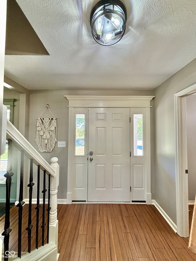 foyer entrance featuring a wealth of natural light, hardwood / wood-style floors, and a textured ceiling