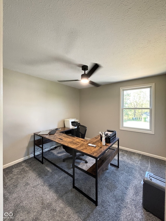 office area with ceiling fan, dark carpet, and a textured ceiling