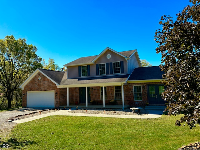 view of property featuring covered porch, a front yard, and a garage