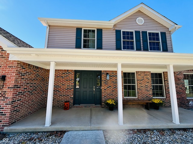 view of exterior entry featuring covered porch