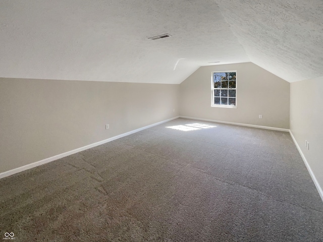 bonus room featuring a textured ceiling, lofted ceiling, and carpet floors