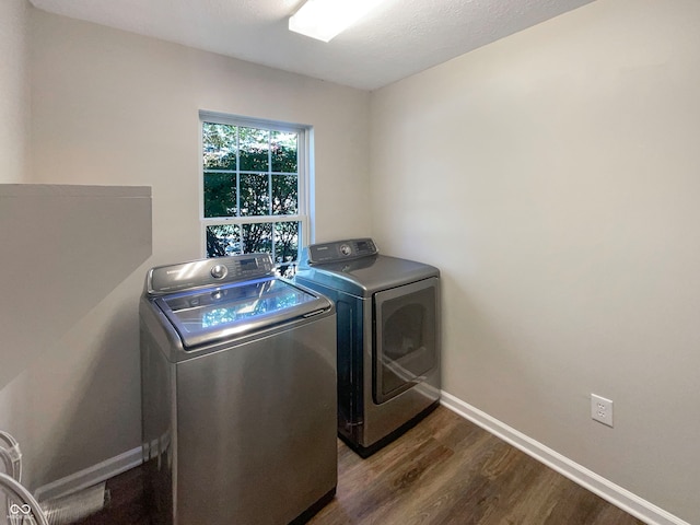 washroom with dark wood-type flooring and washer and dryer