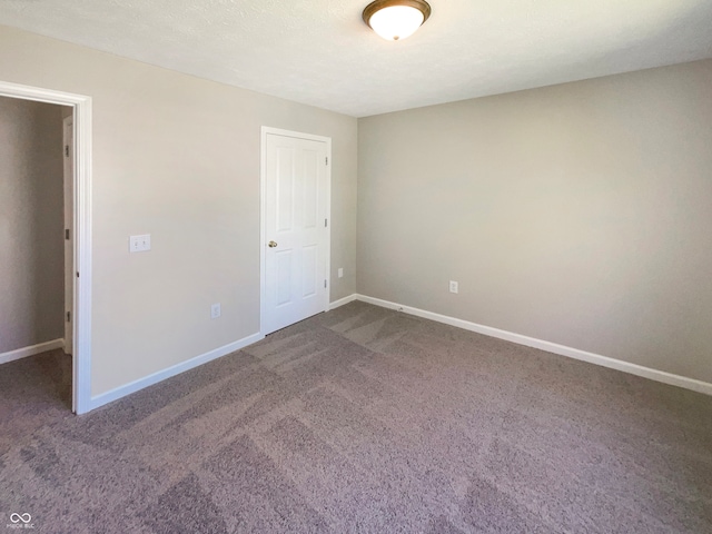 unfurnished bedroom featuring a textured ceiling, carpet flooring, and a closet