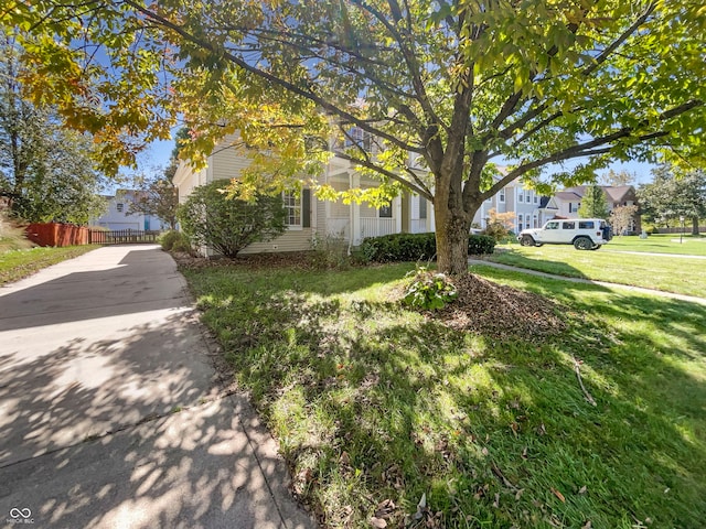 view of property hidden behind natural elements with a front yard