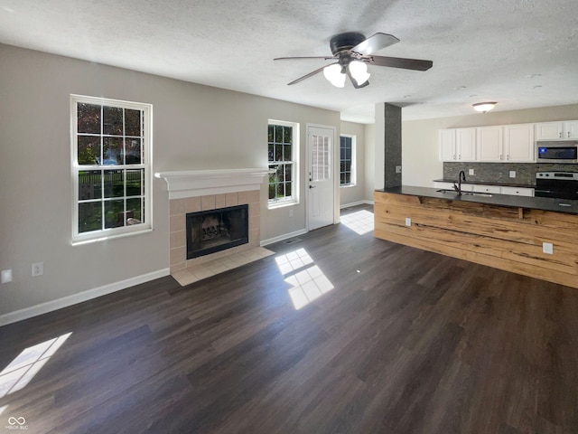 interior space with white cabinets, dark hardwood / wood-style floors, electric stove, a fireplace, and decorative backsplash