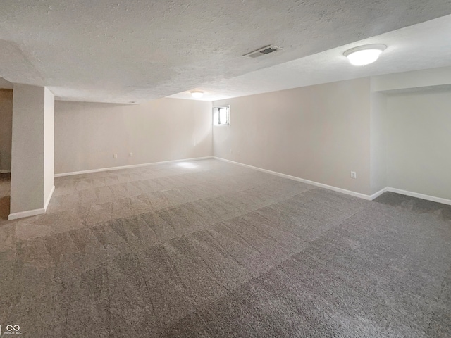 basement featuring a textured ceiling and carpet