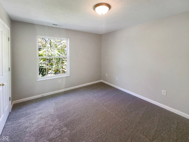 carpeted empty room with a textured ceiling