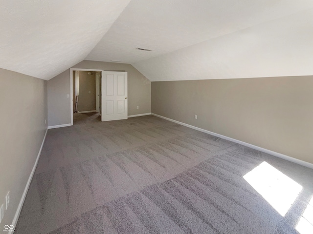 bonus room with carpet and vaulted ceiling