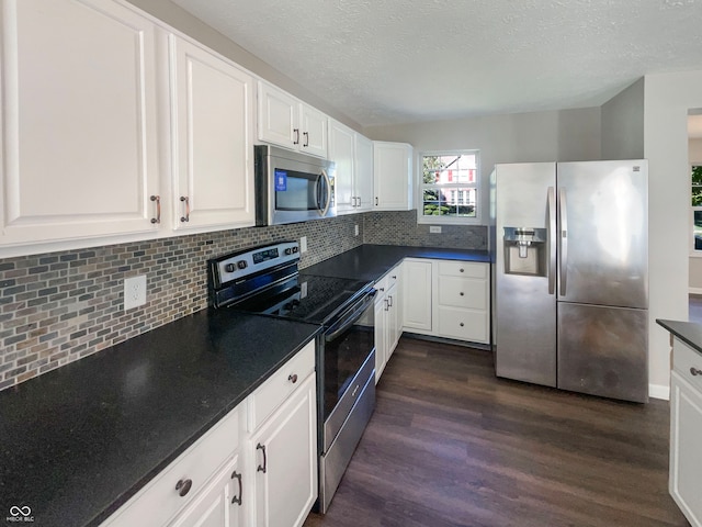 kitchen featuring tasteful backsplash, white cabinets, stainless steel appliances, a textured ceiling, and dark hardwood / wood-style floors