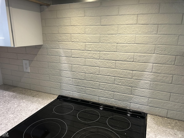 kitchen featuring range, light countertops, black electric cooktop, and white cabinets