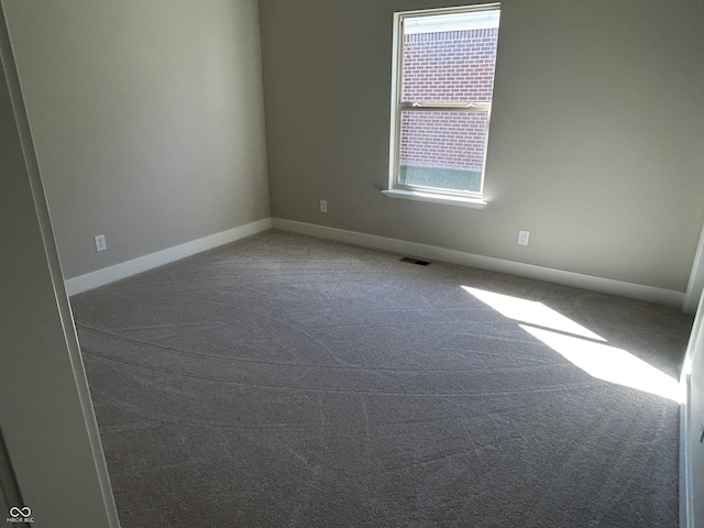 spare room featuring baseboards, visible vents, and carpet floors