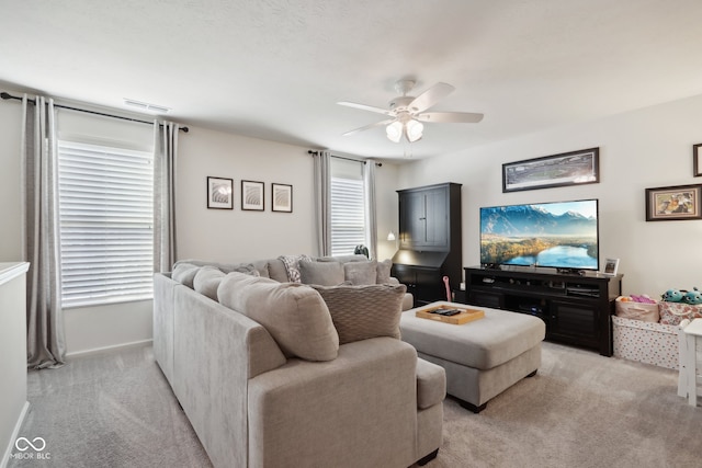 carpeted living room with ceiling fan and plenty of natural light