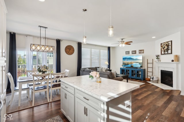 kitchen featuring pendant lighting, a wealth of natural light, white cabinetry, and a kitchen island