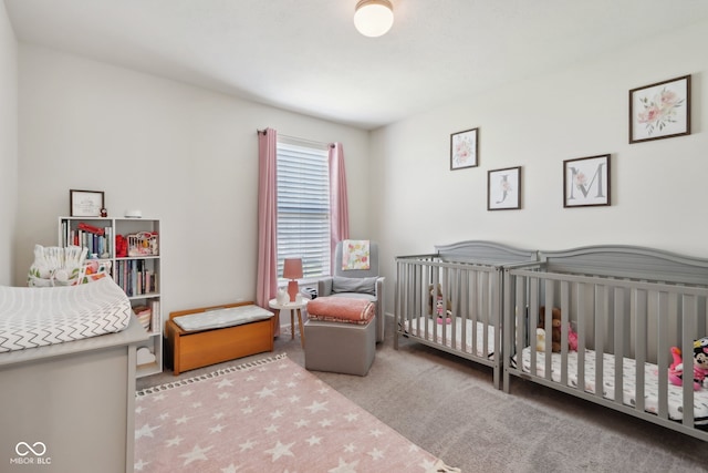 bedroom with a nursery area and carpet