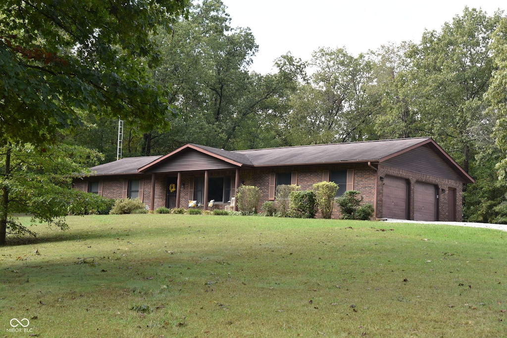 single story home with a garage and a front lawn