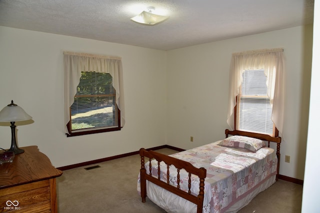 carpeted bedroom featuring visible vents and baseboards