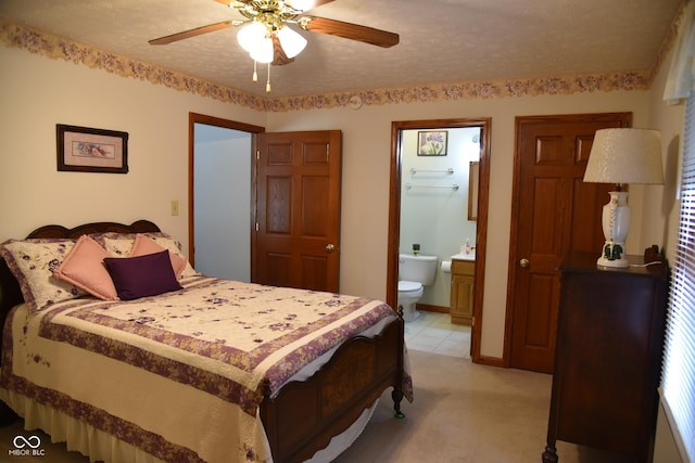 bedroom featuring a ceiling fan, light colored carpet, and ensuite bathroom