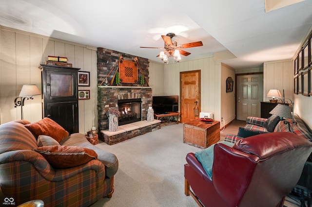 carpeted living room with ornamental molding, ceiling fan, and a fireplace