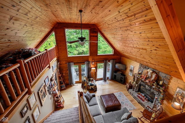 unfurnished living room with wooden walls, a fireplace, and wooden ceiling