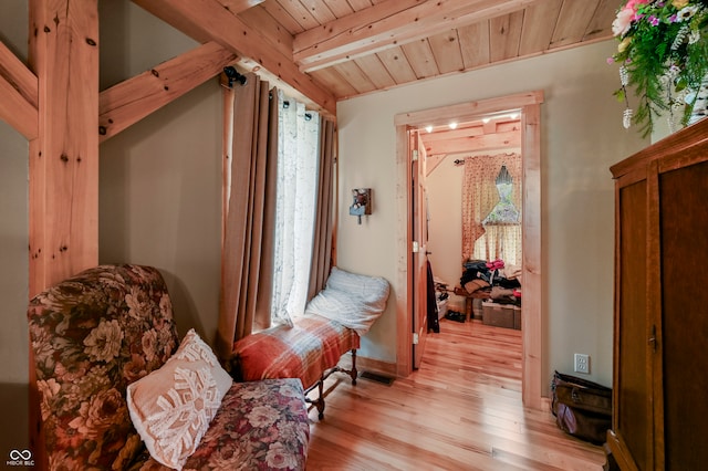 living area with wooden ceiling, beam ceiling, and light hardwood / wood-style flooring