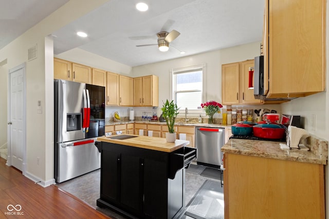 kitchen with light stone counters, ceiling fan, light brown cabinets, stainless steel appliances, and dark wood-type flooring