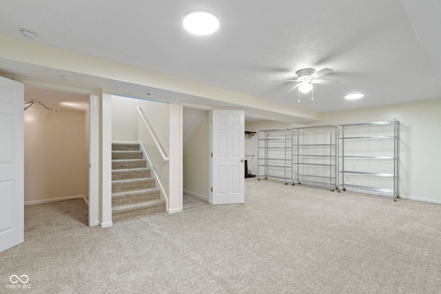 basement with ceiling fan and carpet flooring