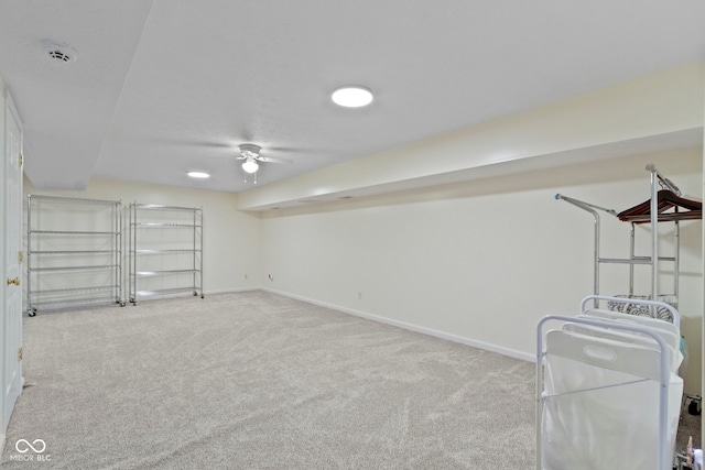 basement featuring ceiling fan and light colored carpet