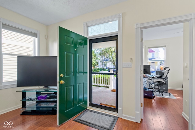 entryway with wood-type flooring and a textured ceiling