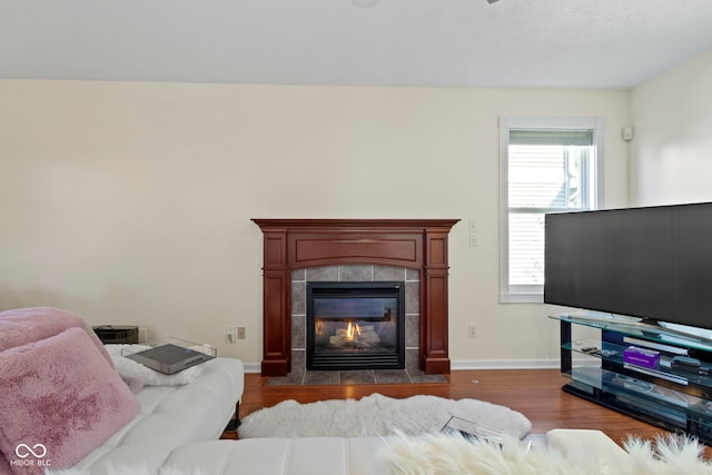 living room featuring dark hardwood / wood-style flooring and a tiled fireplace