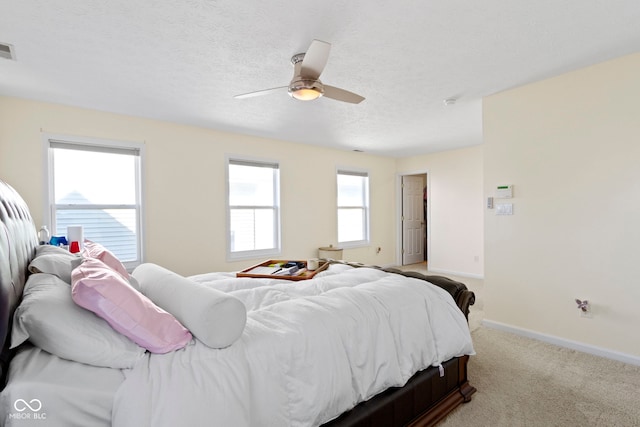 carpeted bedroom featuring ceiling fan and a textured ceiling