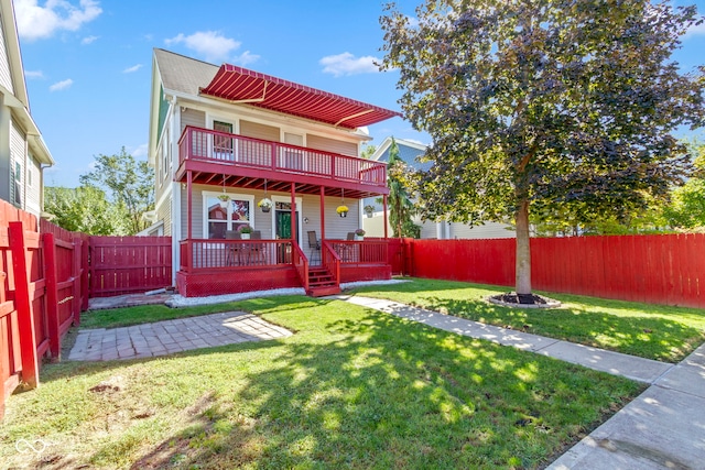 rear view of property with a lawn and a deck