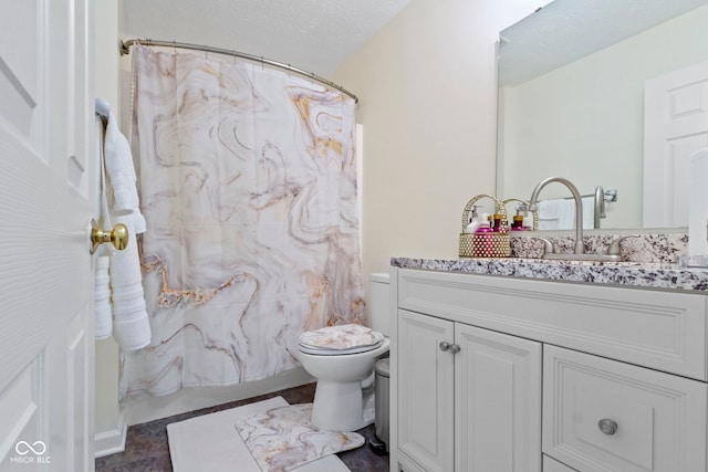 bathroom featuring a shower with curtain, vanity, toilet, and a textured ceiling