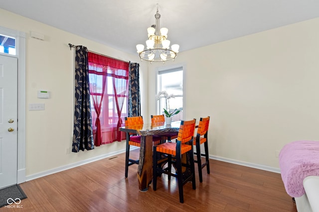 dining space with a notable chandelier and hardwood / wood-style flooring