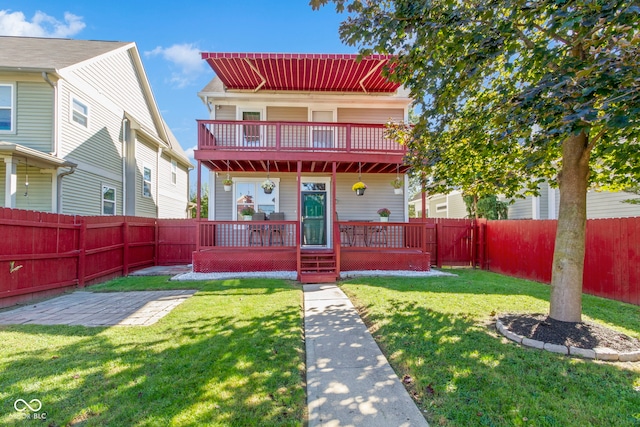 view of front facade with a front yard, a balcony, and a deck