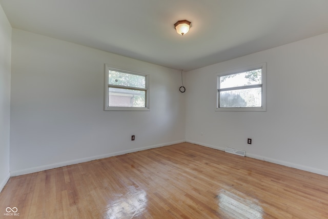 spare room featuring light hardwood / wood-style floors and a healthy amount of sunlight