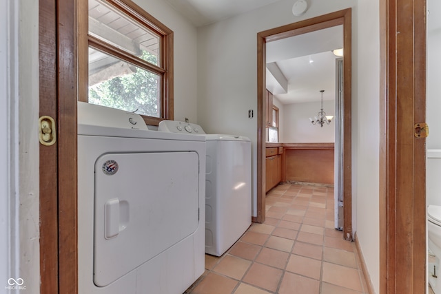 clothes washing area with independent washer and dryer, light tile patterned flooring, and a notable chandelier