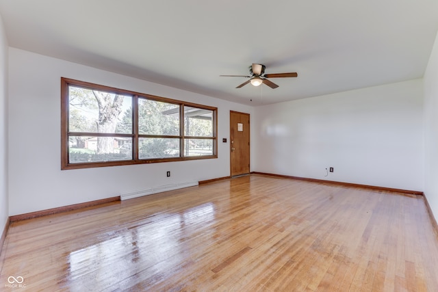 spare room featuring light hardwood / wood-style flooring, a baseboard radiator, and ceiling fan