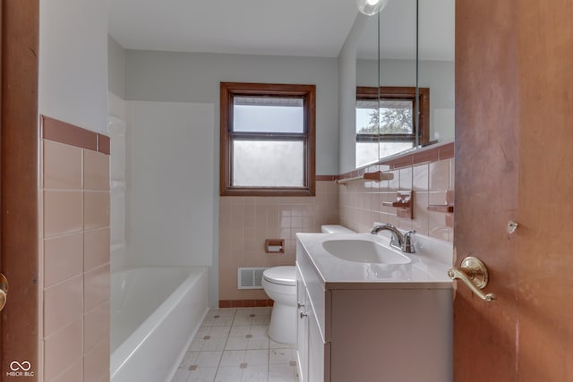 bathroom with tile walls, vanity, and toilet